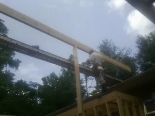 Carpenter setting a ridge beam over a new addition frame — Ice Dam Removal by Roofing Brothers in Chula