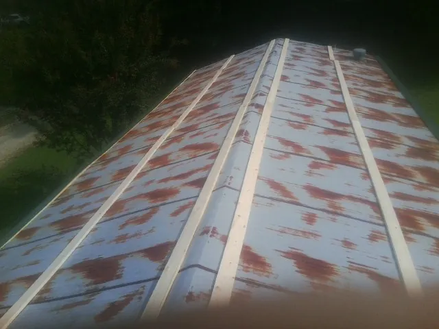 Rusted metal roof panels with new wood purlins before replacement — Storm Damage Roof Repair in Chula by Roofing Brothers
