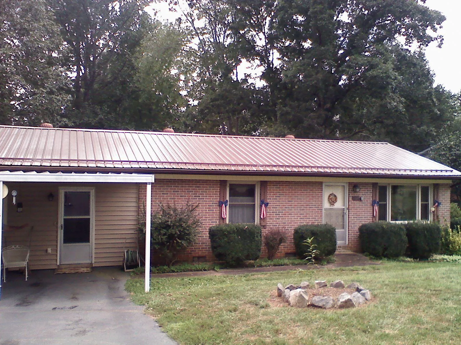 Bronze metal roof and carport on a brick ranch home — Roof Repair work by our crew in Chula